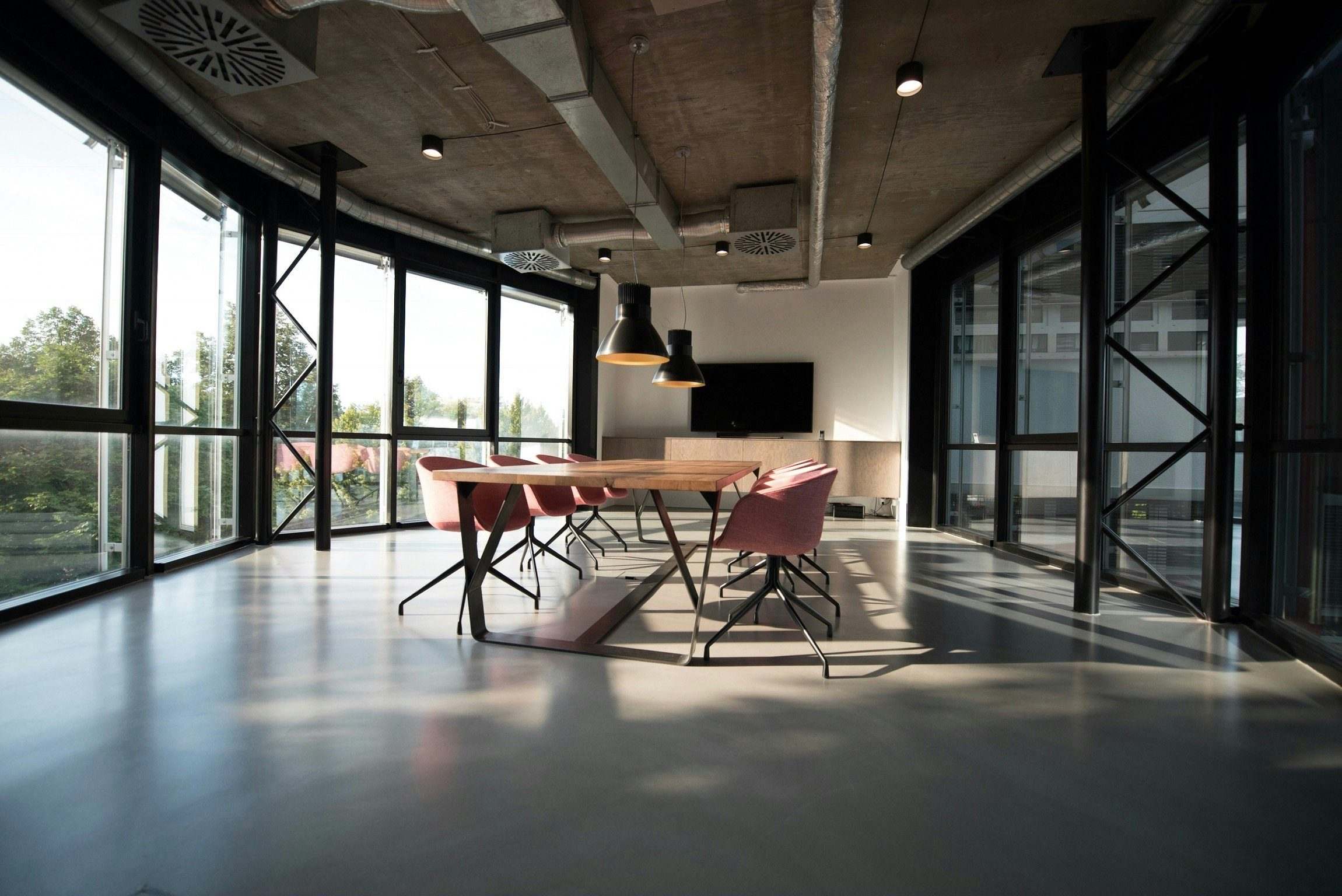 Bright modern meeting room with a long table and floor-to-ceiling windows