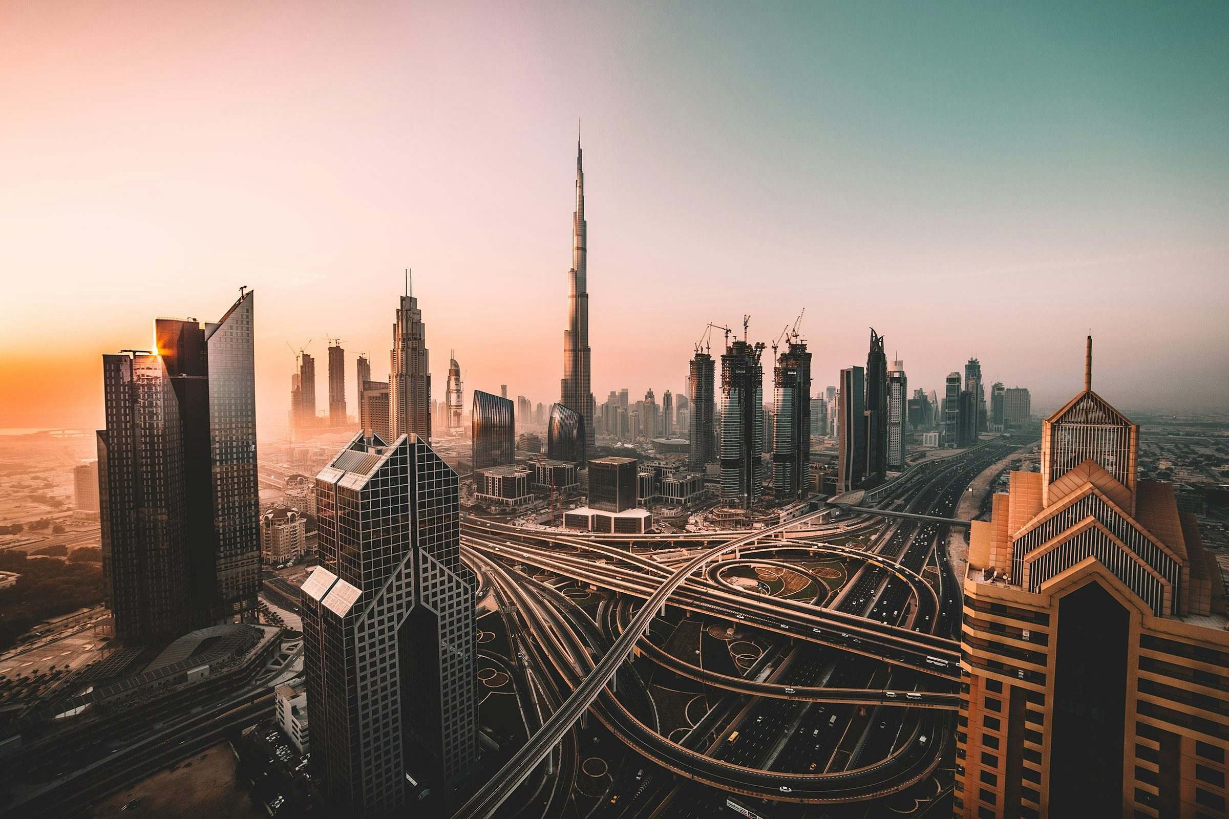 Dubai skyline of glass towers and highways glowing at dusk